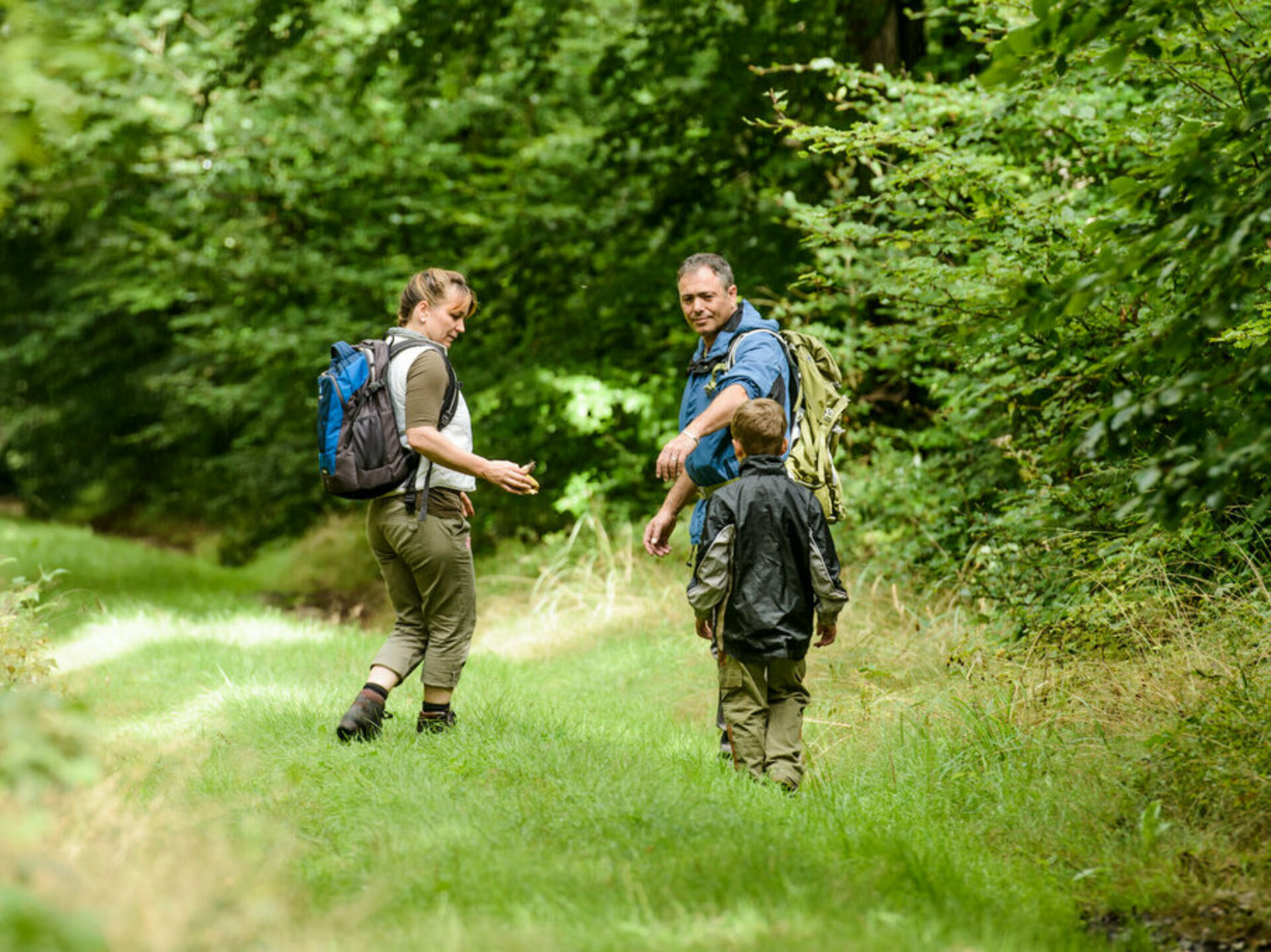 zwei Wandernde mit ihrem Kind im Wald
