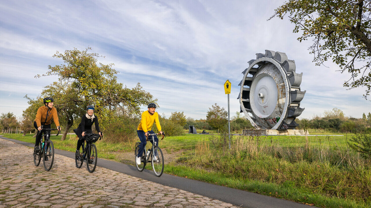 Drei Radfahrende auf einem Radweg