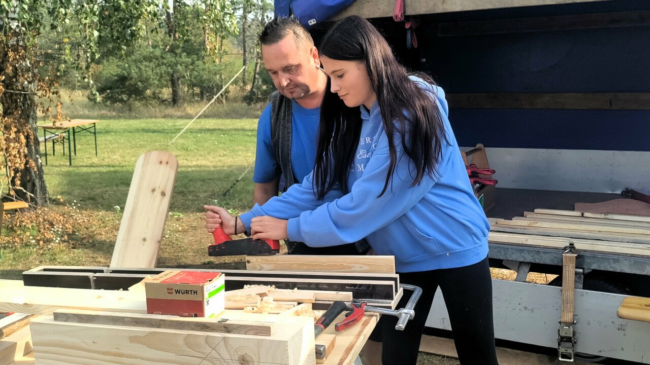 Handwerker und Mädchen bei der Holzbearbeitung