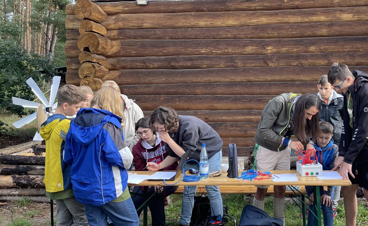 Jugendliche, die vor einer Blockhütte arbeiten